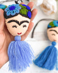 close up shot of embroidered frida tassel in blue - holding in hand