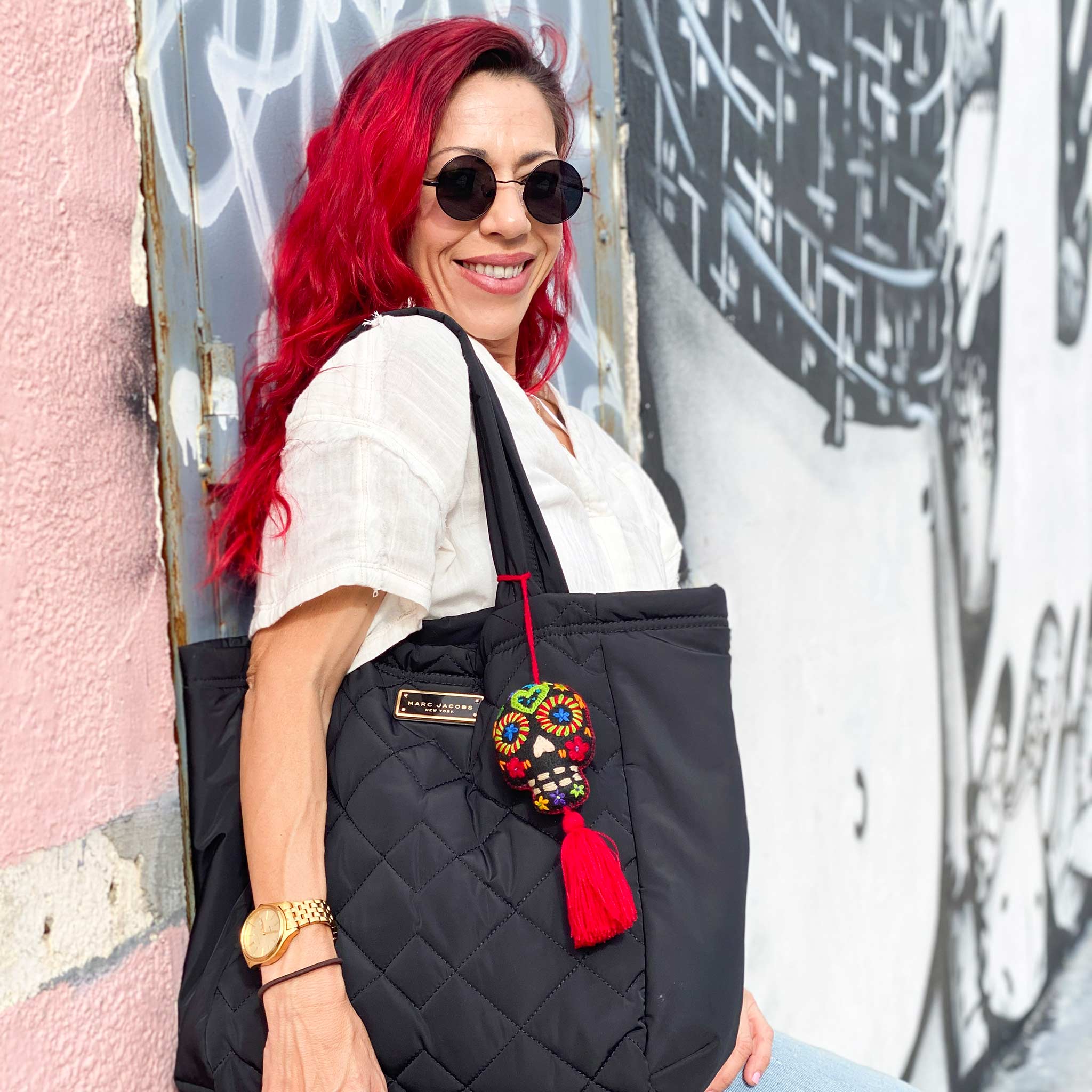 Hand embroidered red sugar skull tassel on a woman&#39;s black tote