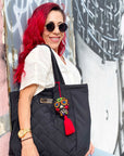 Hand embroidered red sugar skull tassel on a woman's black tote